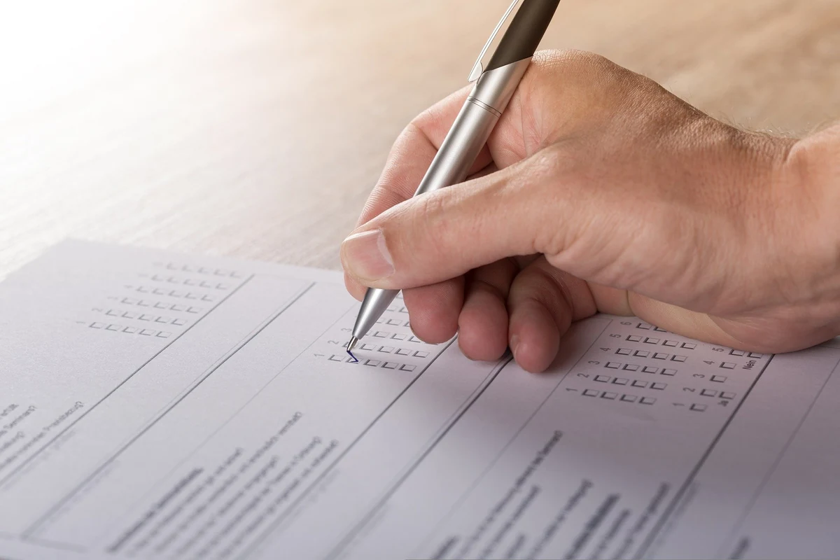 A participant marking their answers on a questionnaire with a pen.